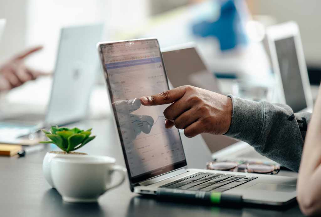 man pointing at laptop screen